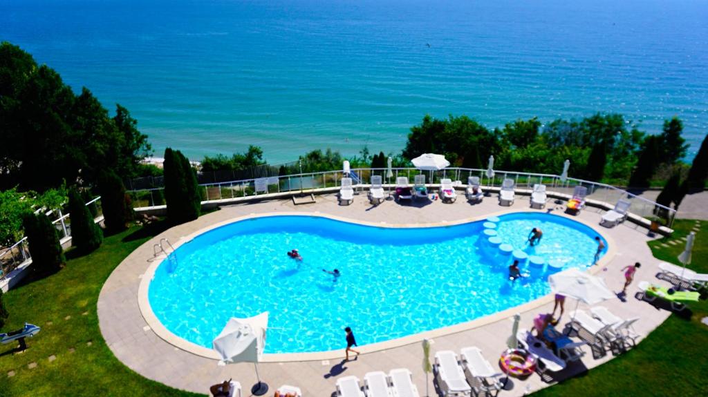 een uitzicht over een zwembad met de oceaan op de achtergrond bij Плажни Апартаменти Силвър Бийч - Silver Beach Sea Apartments in Byala