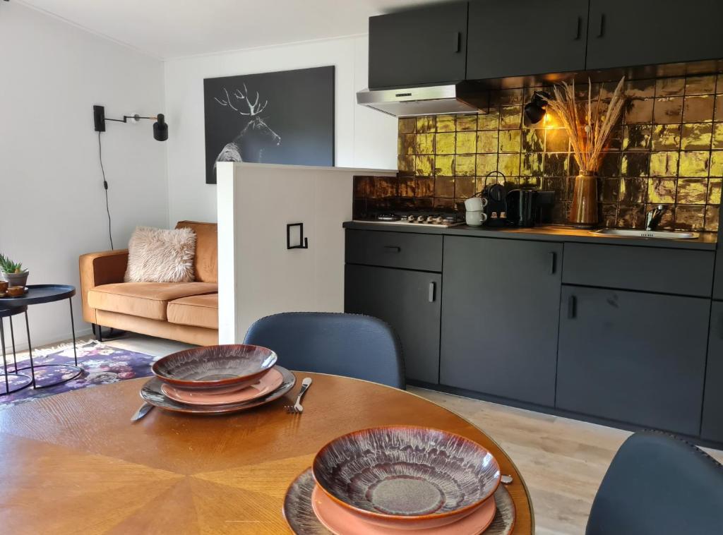 a kitchen with a wooden table with plates on it at Luxe Tiny House op de Veluwe in Nunspeet