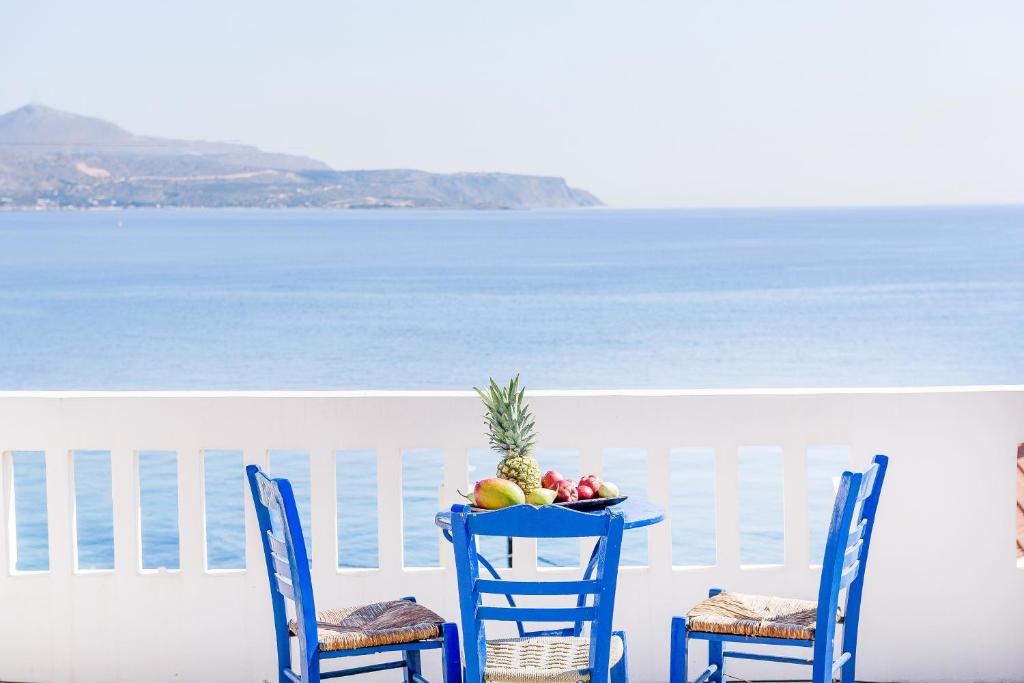 a table with a bowl of fruit and two chairs at Kalyves Bay in Kalyves
