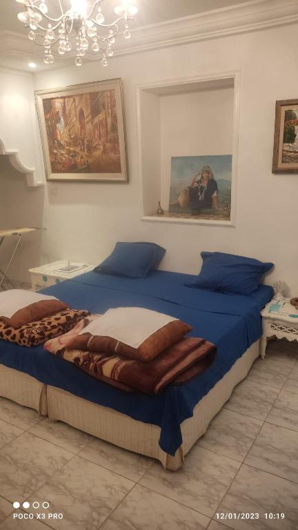 a bedroom with two beds and a person taking a picture at Jolie Maison au centre de Sidi Bou Said in Sidi Bou Saïd