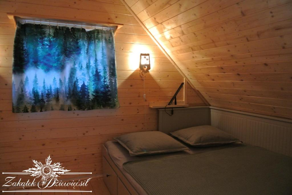 une chambre avec un lit dans une cabine avec une fenêtre dans l'établissement Zakątek DZIEWIĘĆSIŁ, à Przyborów