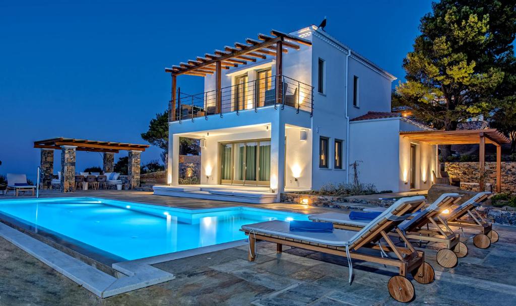 a villa with a swimming pool in front of a house at Stargaze Villas in Panormos Skopelos