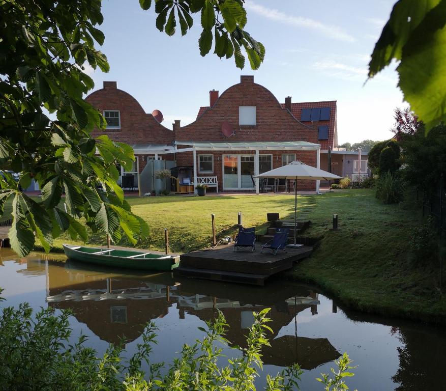 a house with boats on the water in front of it at Grachtenkate in Greetsiel