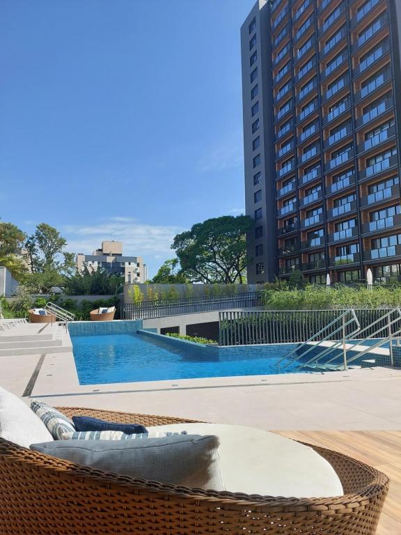 a swimming pool with a building in the background at MyHome - Studio de Luxo próximo ao Shopping Iguatemi in Porto Alegre