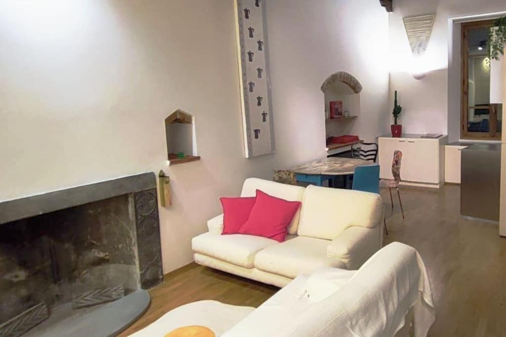 a living room with a white couch and a fireplace at Appartamento Torre della Buca in Prato