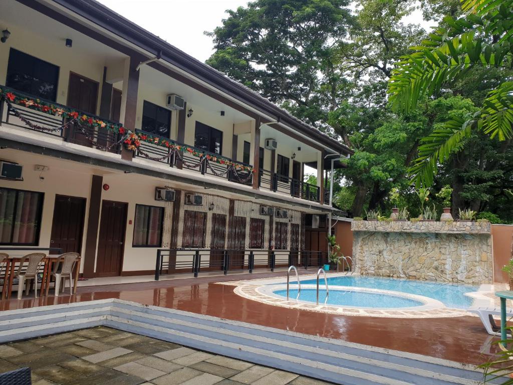 un edificio con piscina frente a un edificio en DIAKOPES INN en Puerto Princesa