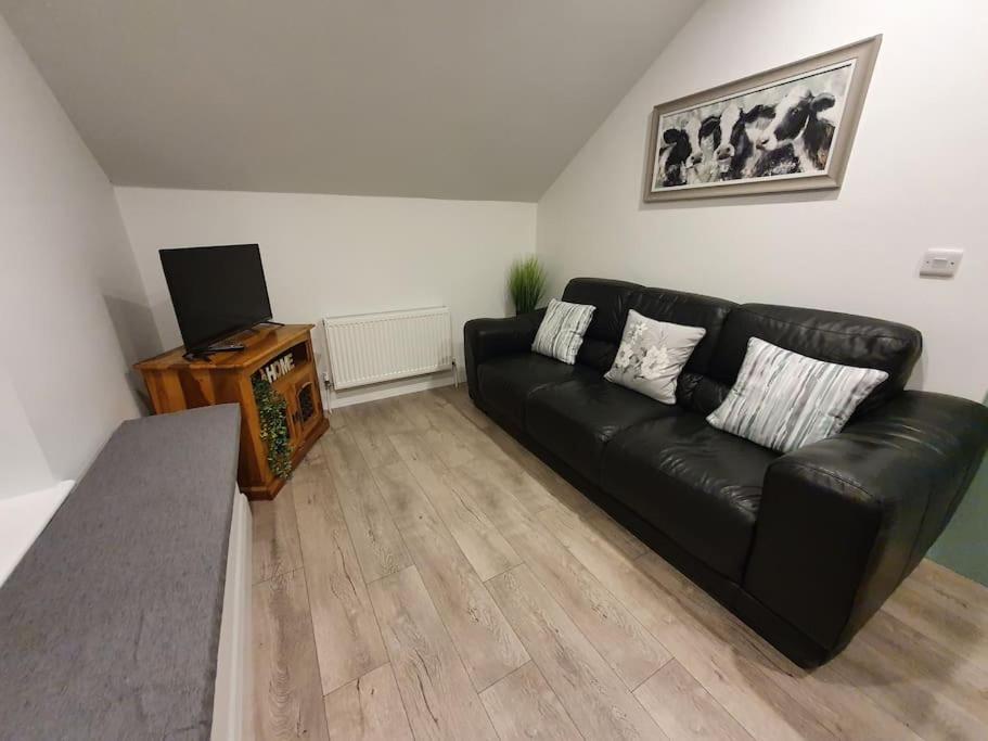 a black leather couch in a living room at The Loft, Killybegs in Donegal