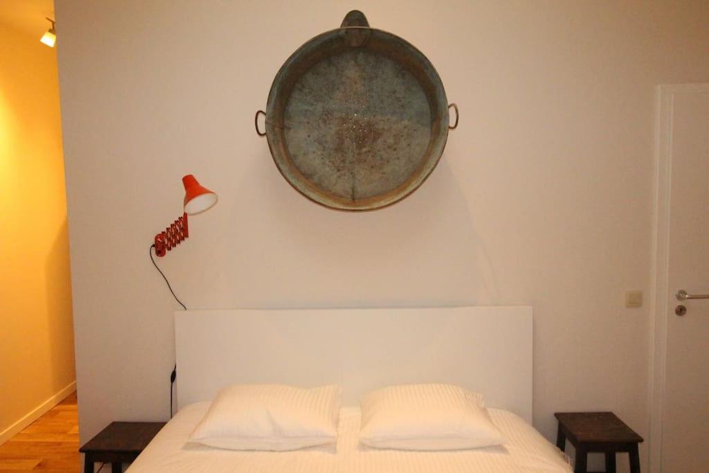 - un lit avec 2 oreillers et un plateau sur le mur dans l'établissement Duplex de 3 chambres en plein centre ville - 82/3A, à Liège