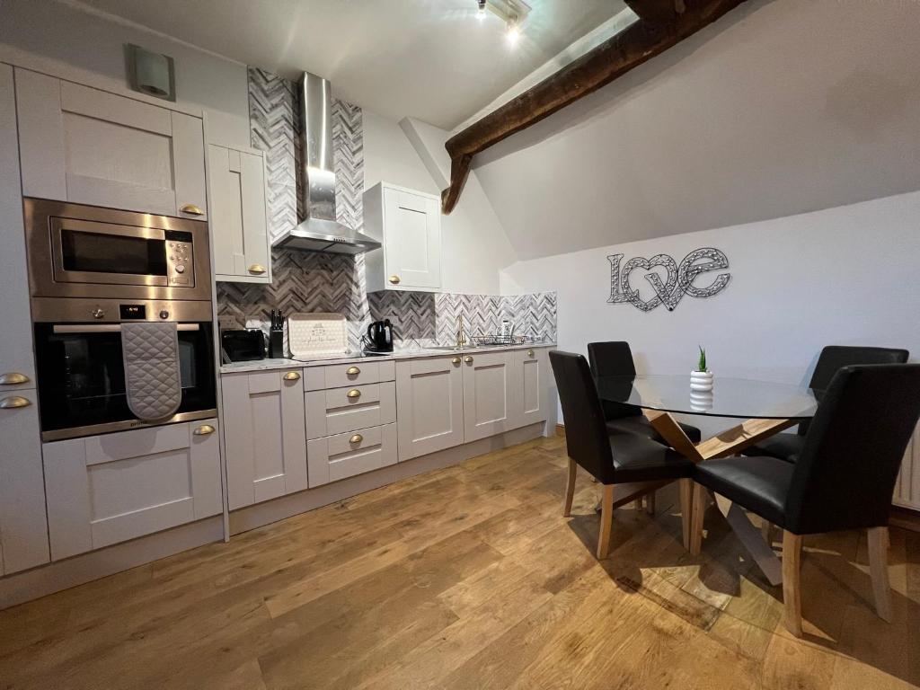 a kitchen with a table and chairs in a room at King Charles Barns Nr Blists Hill in Telford