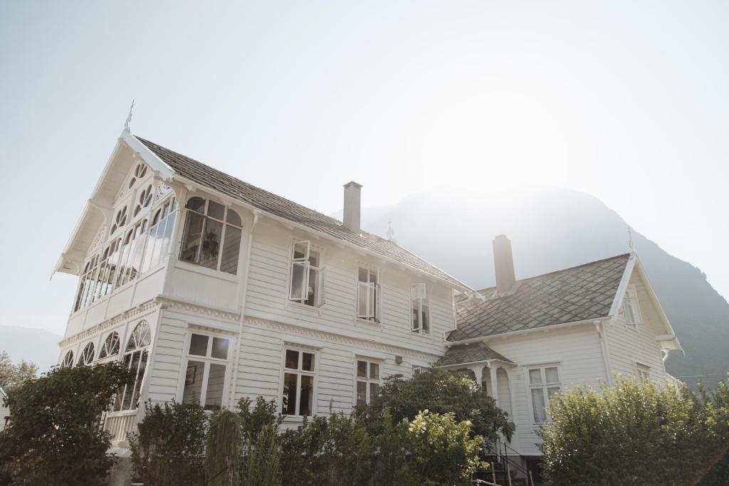 a white house with two chimneys on top of it at Hardanger Fjord Lodge in Bondhus