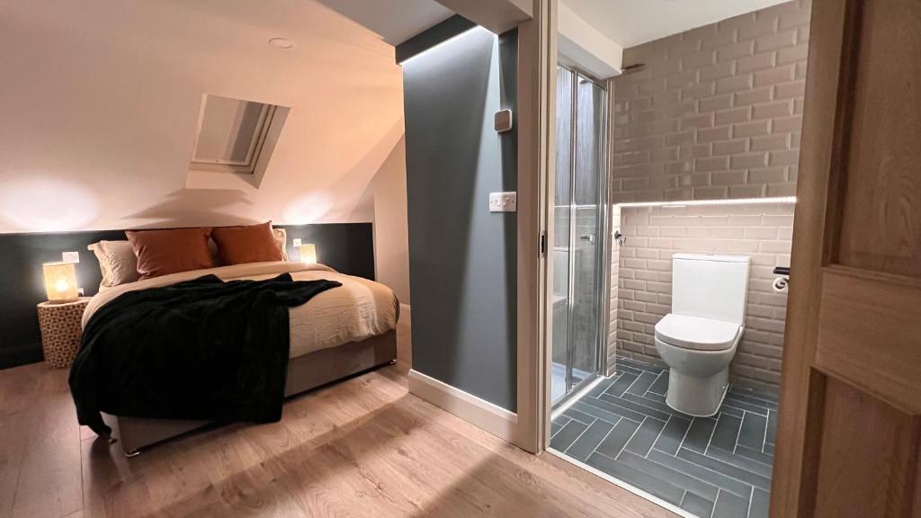 a bedroom with a bed and a bathroom with a toilet at CHAMBERS RISE - City Centre Stays in Derry Londonderry