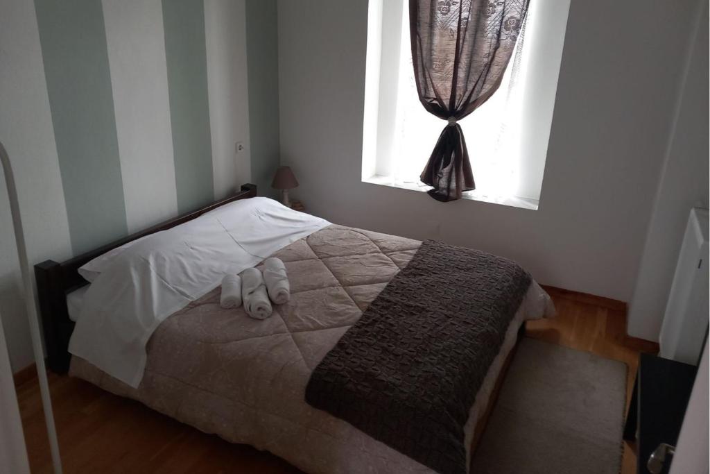 uma cama num quarto com uma janela em Ξενώνας Βογατσικού em Vogatsiko