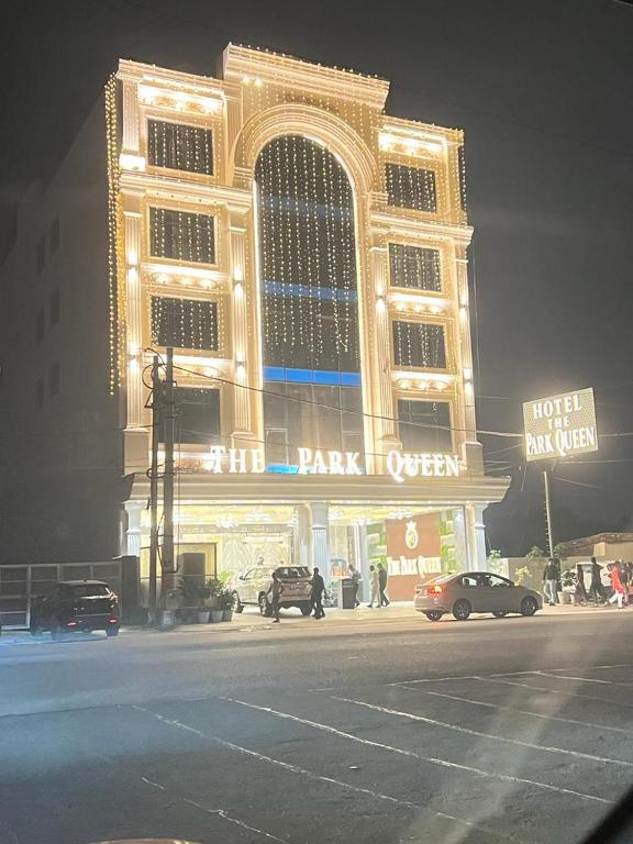 a large building with cars parked in front of it at THE PARKQUEEN in Rohtak