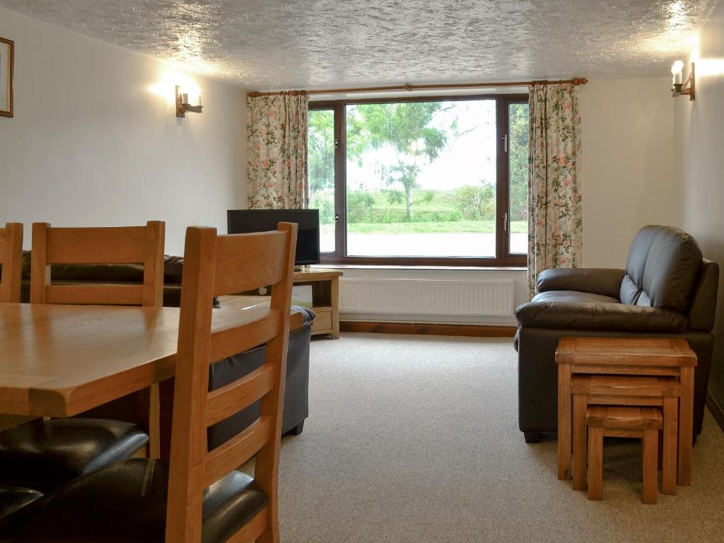 a living room with a table and chairs and a window at Stable Cottage 5 - Ukc3744 in Bawdeswell