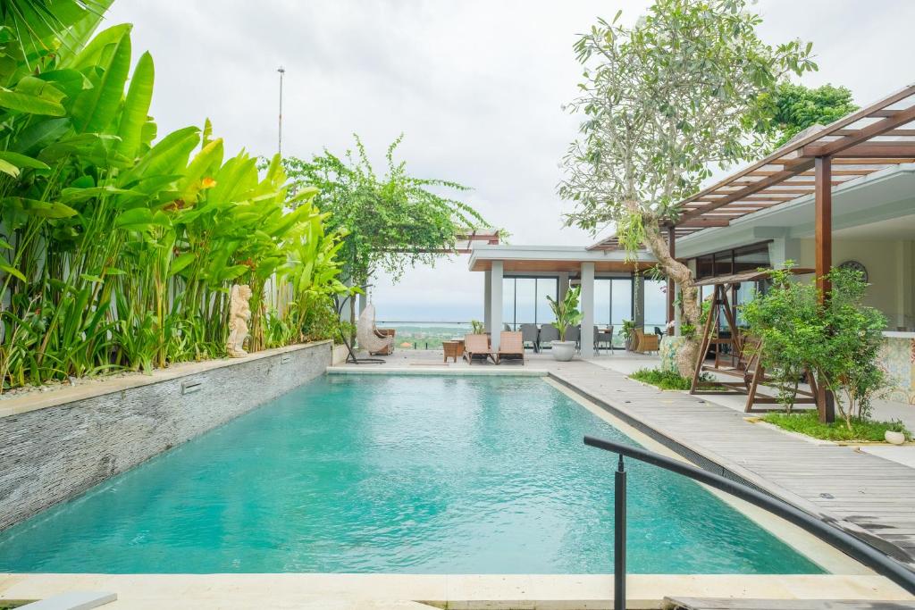 einen Infinity-Pool in einer Villa mit dem Meer im Hintergrund in der Unterkunft The Lavana Villa Puri Hawila Jimbaran - 5 Bedroom Villa in Jimbaran
