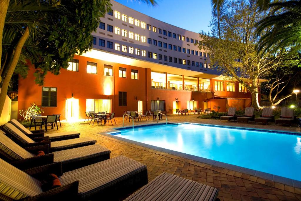 un hotel con piscina frente a un edificio en SunSquare Cape Town Gardens en Ciudad del Cabo