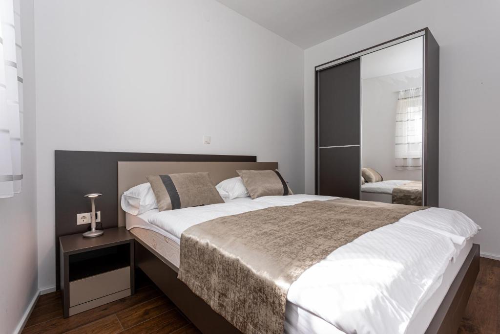 Postel nebo postele na pokoji v ubytování Apartments Crnekovic Tomislava 8A