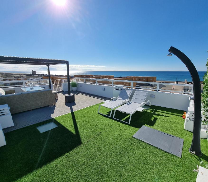 a rooftop patio with a view of the ocean at Ático Los Flamingos. Exclusive terrace with views in El Cabo de Gata