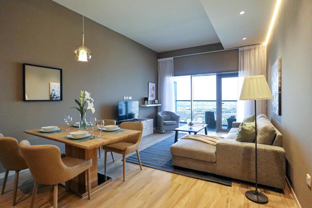 ドバイにあるWelHome - Evergreen Apartment Amidst Vibrant JVC With Poolのリビングルーム(ソファ、テーブル付)