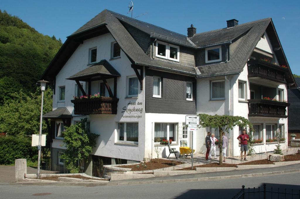 ein großes weißes Gebäude mit Leuten, die davor stehen in der Unterkunft Haus am Stryckweg in Willingen