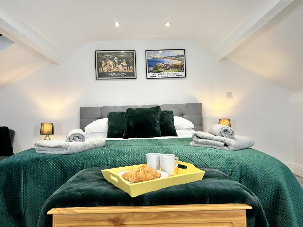 um quarto com uma cama verde e uma bandeja em Luxurious Harrogate Penthouse with Free Parking em Harrogate