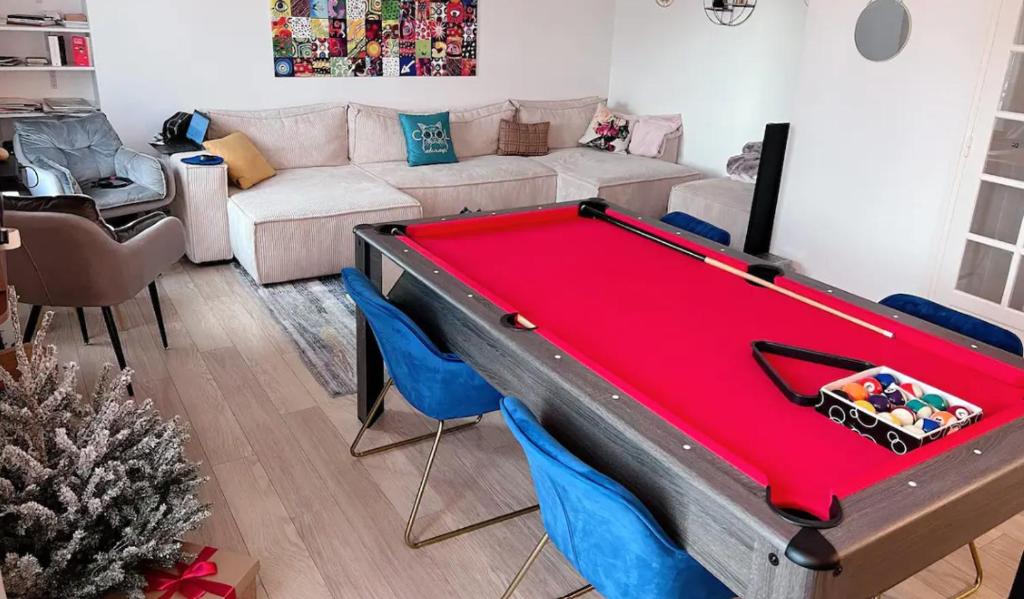 ein Wohnzimmer mit einem roten Billardtisch. in der Unterkunft Elegance et Confort - Votre Havre Luxueux pour les Jeux Olympiques à Paris in Puteaux