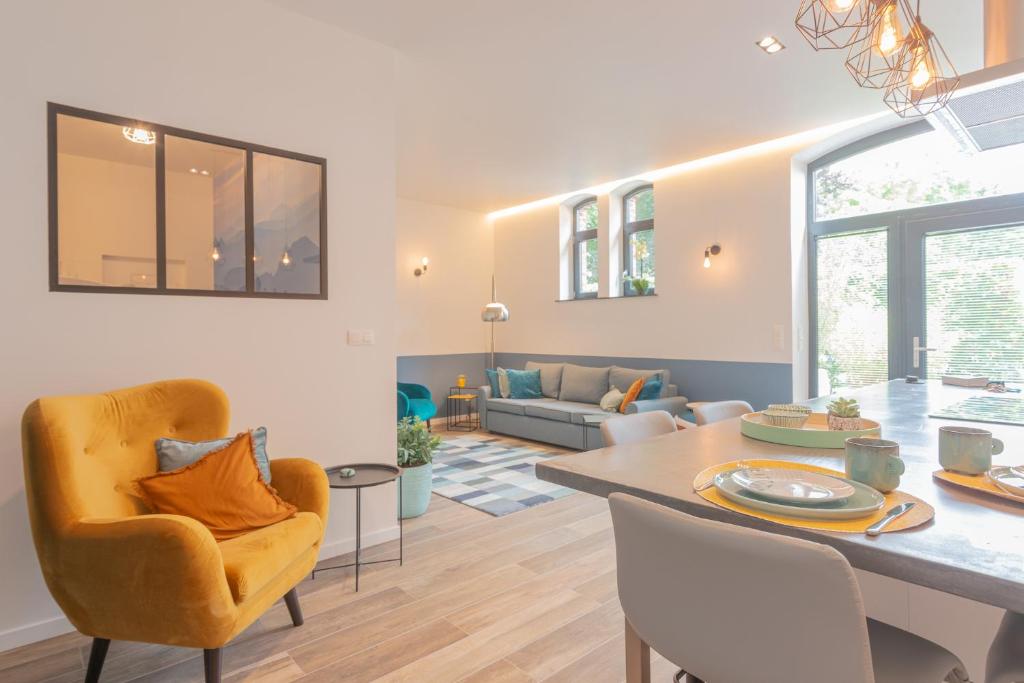 a dining room and living room with a table and chairs at Superbe appartement 2 chambres dans un clos privé proche de Waterloo in Genappe