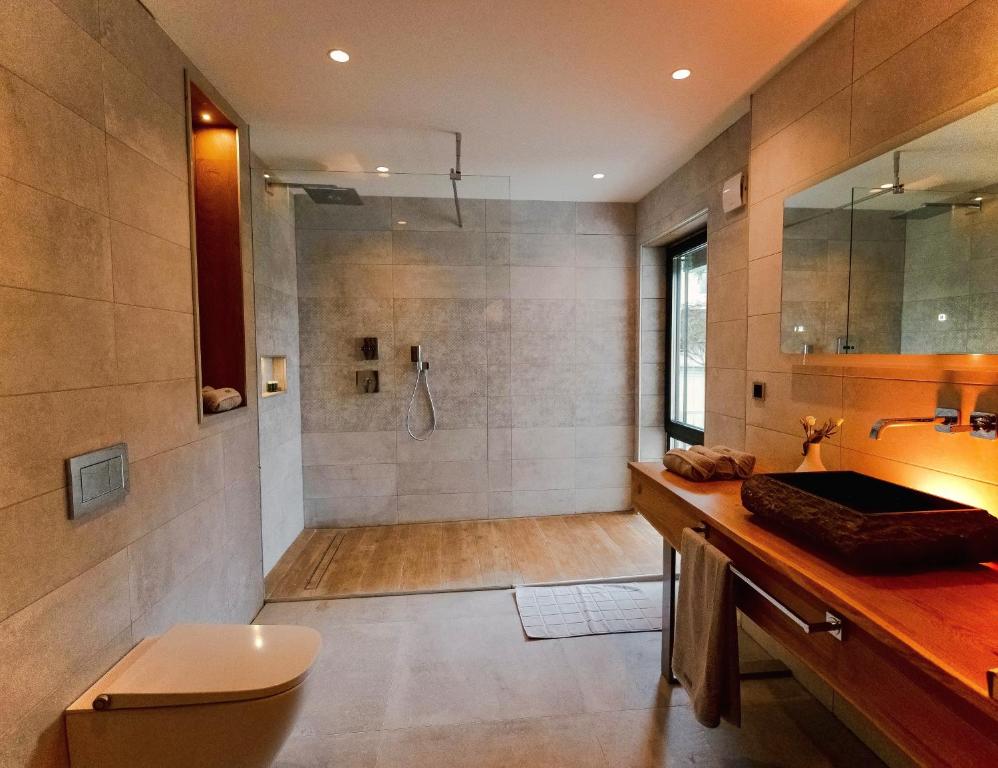 a large bathroom with a shower and a sink at Private Spa Lodge Odenwald in Lindenfels