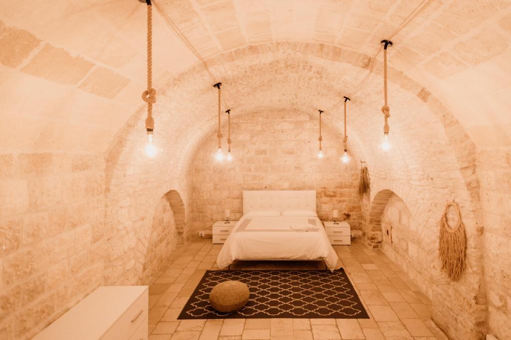 モルフェッタにあるA Stare - Stone Apartment in the Historic Center - Molfettaのレンガの壁にベッドが備わる部屋
