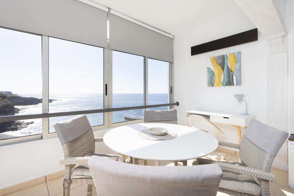 une salle à manger blanche avec une table et des chaises blanches dans l'établissement Tranquilidad, playa y vistas al mar, à Callao Salvaje