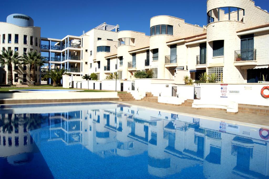 une piscine en face d'un bâtiment dans l'établissement REGIA BAHIA - Cabo Roig - SEA VIEW, à Playas de Orihuela