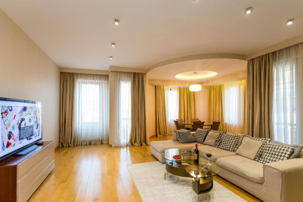 a living room with a couch and a tv at Central Cosy 5BD-5BATH Apartment in Tbilisi City