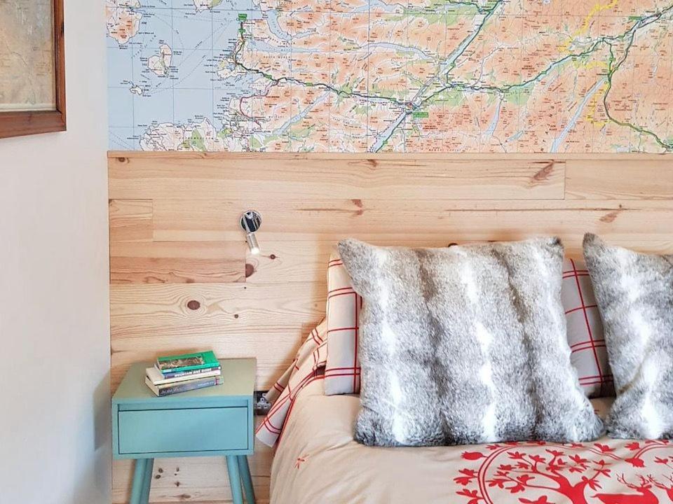 1 dormitorio con 1 cama con mapa en la pared en The Bakehouse - by Where Stags Roar en Newtonmore