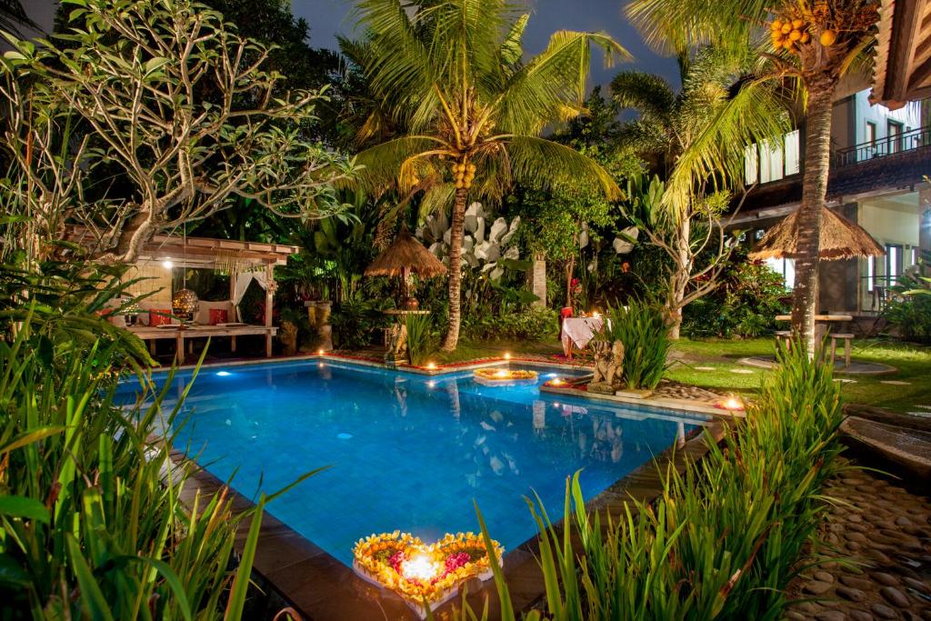 a swimming pool in a garden at night at Arimba at Bisma in Ubud
