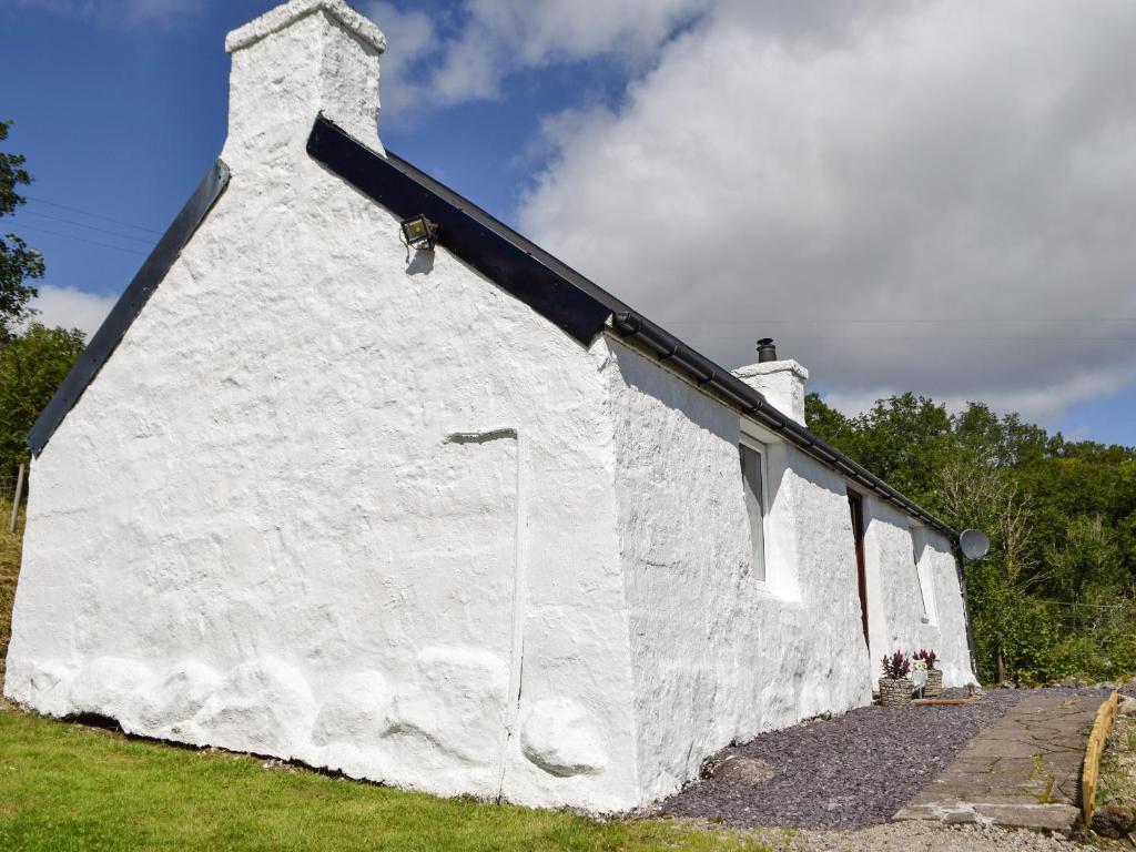 un edificio blanco con techo negro en The Old Croft House en Strontian