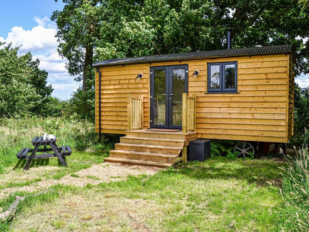 a wooden tiny house with stairs and a picnic table at Chestnut - Ukc4848 in Cantley