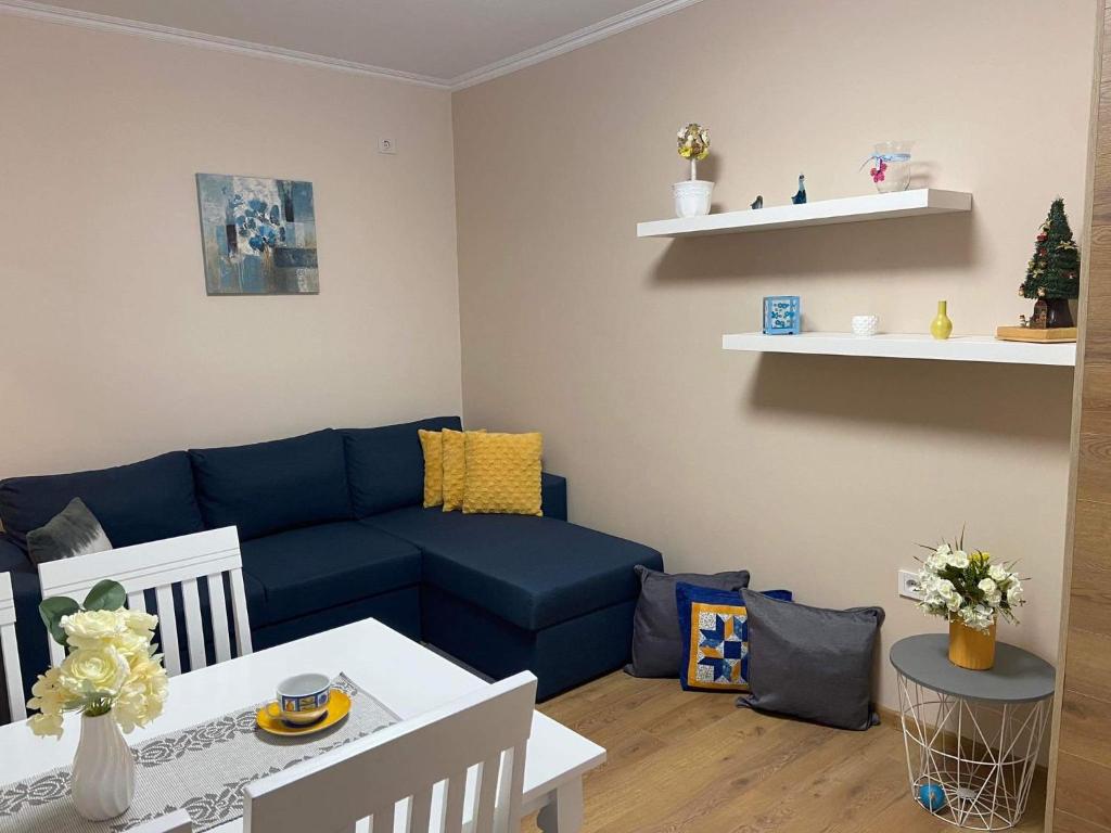 sala de estar con sofá azul y mesa en Gardenia Apartment, en Veliko Tŭrnovo