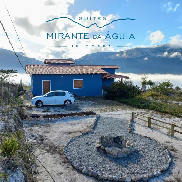 a car parked in front of a blue house at Suítes Mirante da Águia in Ibicoara