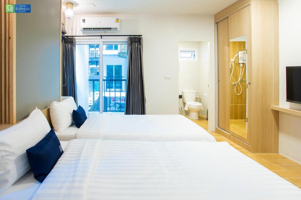 Postel nebo postele na pokoji v ubytování Zayn Express & Suites