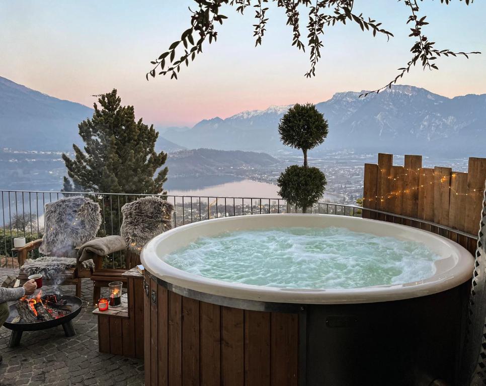eine Whirlpool-Badewanne mit Bergblick in der Unterkunft Alpinlake Lodge & Wellness in Bosentino
