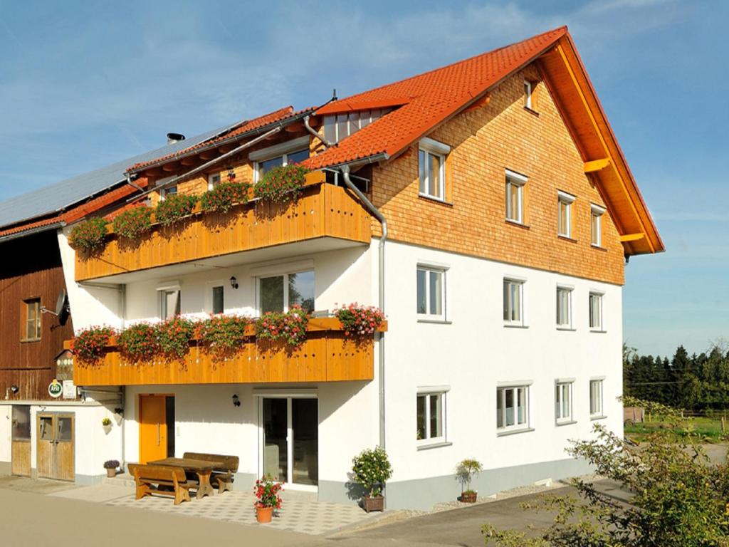 a large white building with a red roof at Ferienhof Bitschnau in Lindenberg im Allgäu