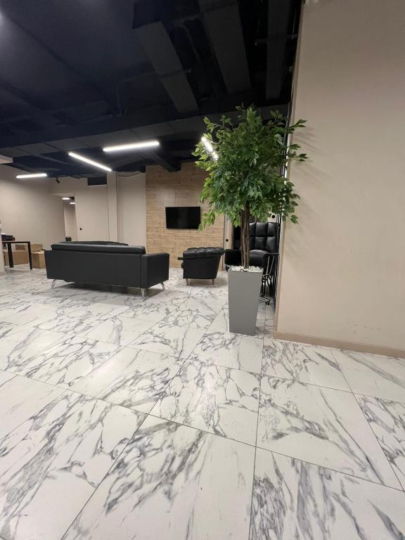 Un vestíbulo con suelo de mármol y una planta en maceta. en Mega Hostel, en Almaty