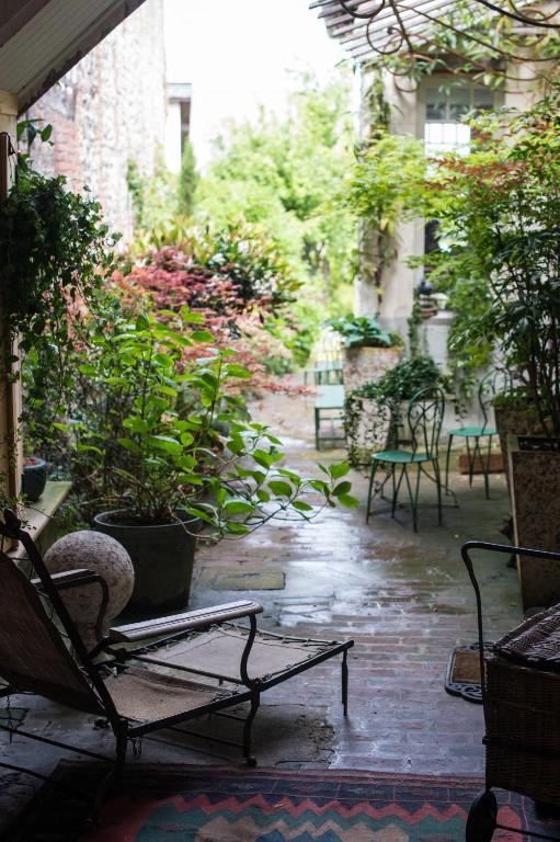a patio with chairs and plants in the rain at Logis Saint-Léonard in Honfleur