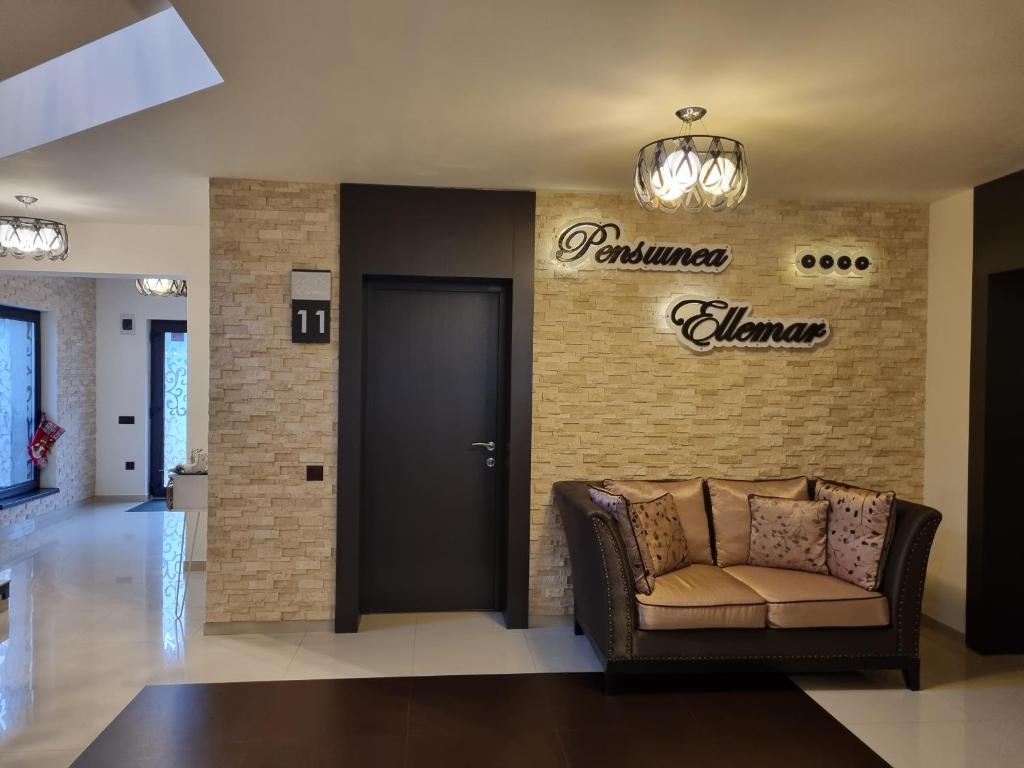 a lobby with a couch and a sign that reads palmer almanac at Pensiunea Ellemar in Vatra Dornei