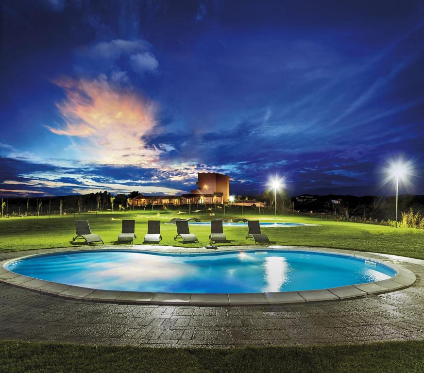 a large swimming pool in front of a large building at Mercury Boutique Hotel in SantʼAntìoco