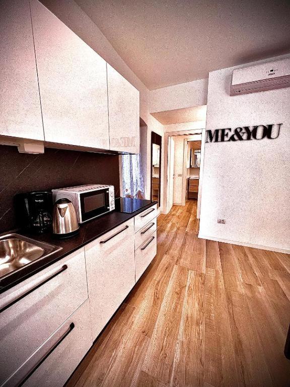 a kitchen with a sink and a microwave at Welcome Traveller AMORE APARTMENTS in Bardolino