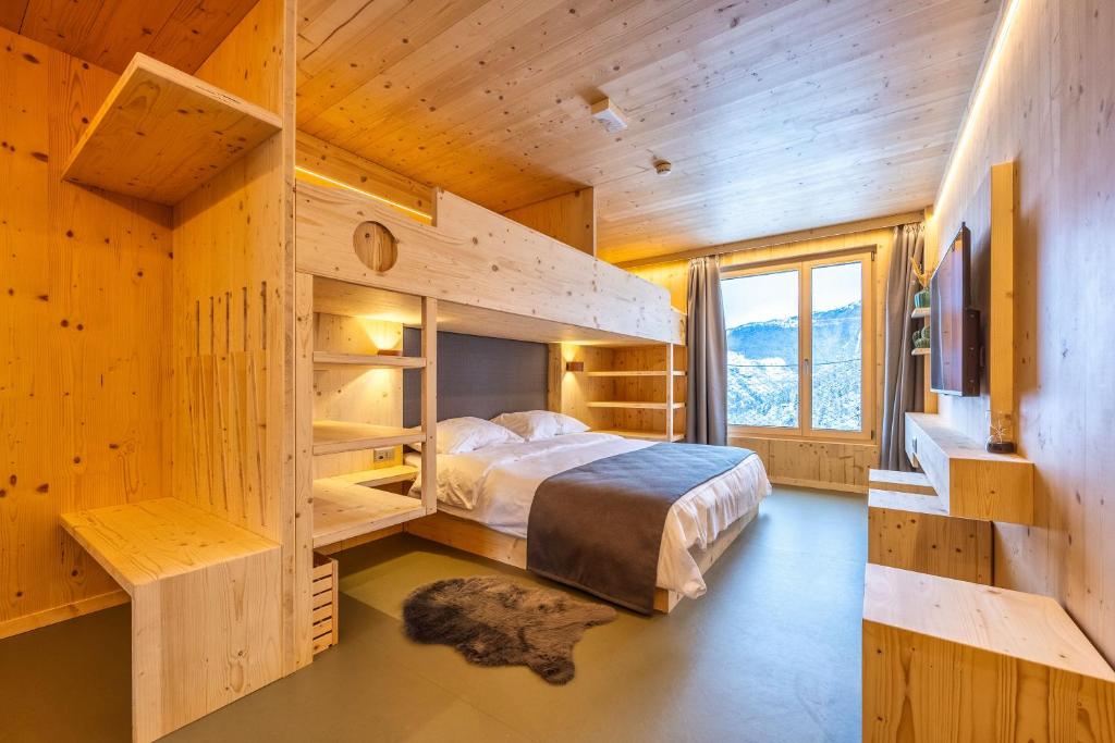 ein Schlafzimmer mit einem Bett in einer Holzhütte in der Unterkunft MAD Mount Hotel & Spa in Nendaz