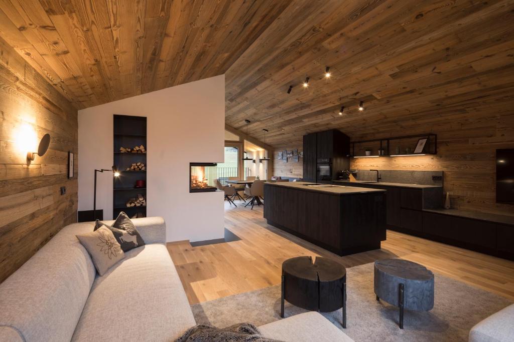 a living room and kitchen with wooden ceilings at Haus Sonnblick Chalet in Reith im Alpbachtal