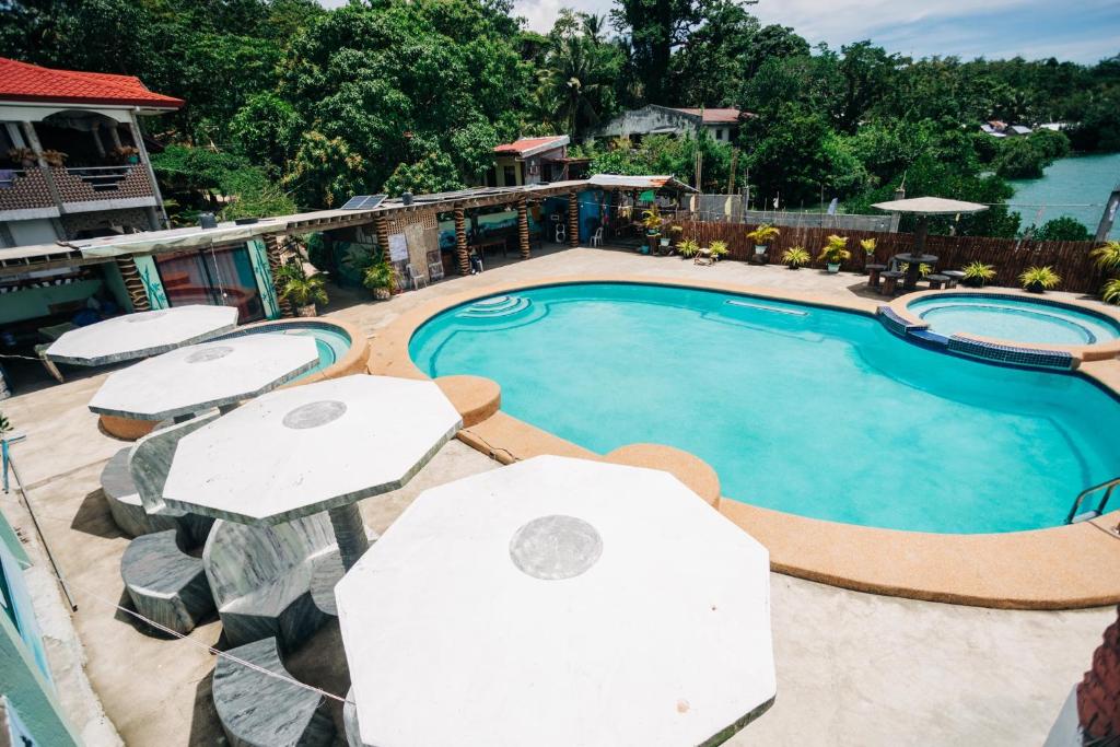 uma grande piscina com guarda-sóis e uma piscina em La Casa de Samonteza em Camotes Islands