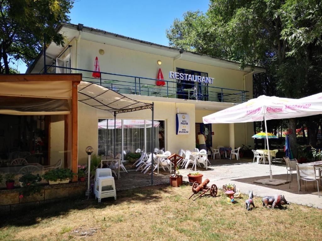 un restaurante con mesas, sillas y sombrillas en хотел Русалка, en Varna